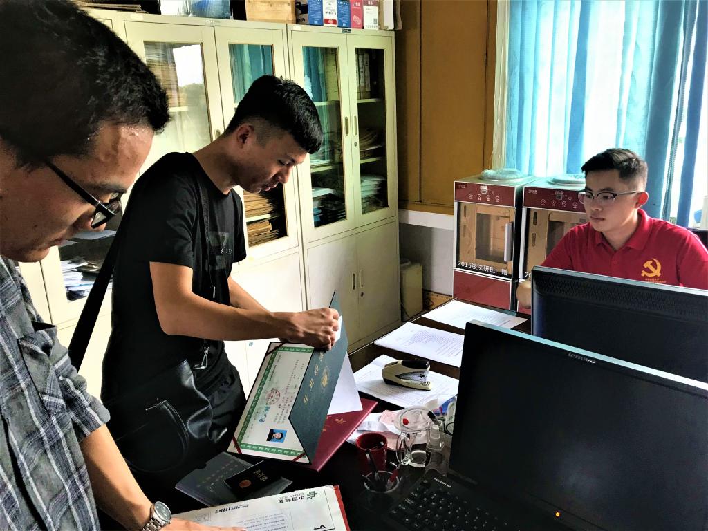 (图为员工党员为研究生新生报到注册)